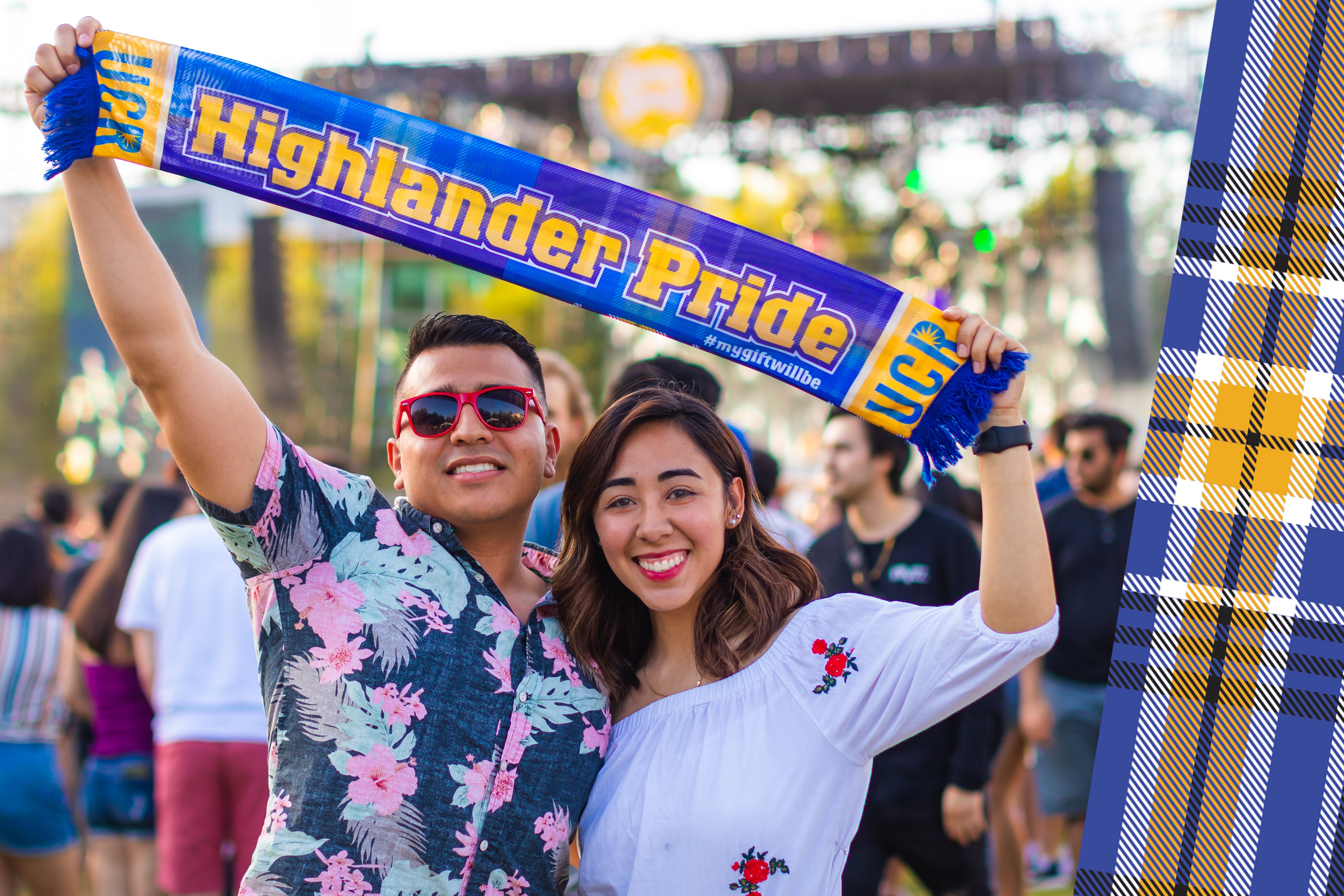 UCR alumni holding "Highlander Pride" scarf at campus music festival.