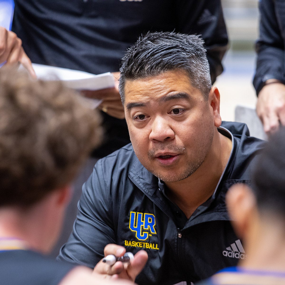 UCR's men's basketball coach, Mike Magpayo, chats with his team during a timeout during a game. Maypayo is the first Division I men's basketball coach of Asian descent.