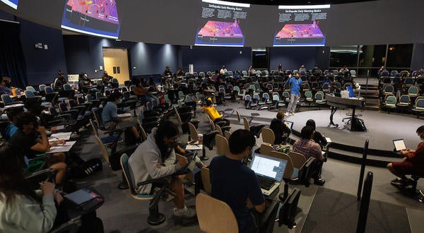 Students engaged during lecture in in-the-round lecture hall.