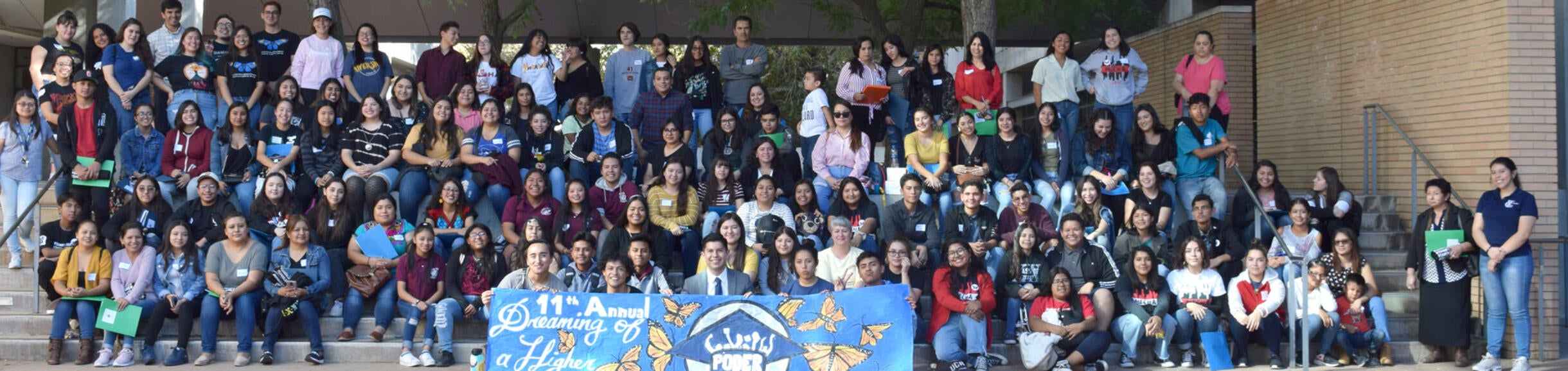 A large group of student gather for a photo on the UC Riverside campus