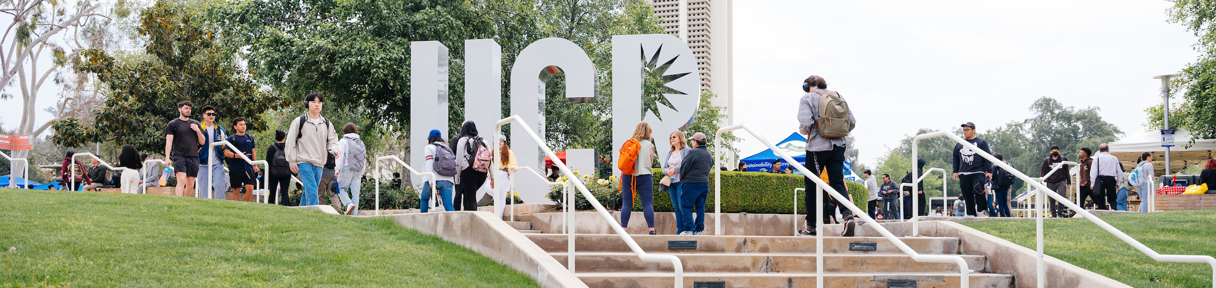 A view of the UCR letter sculpture on the UC Riverside campus. Students walk in front of the sculpture.