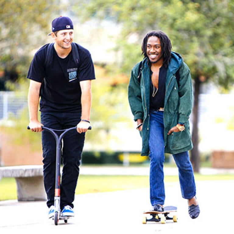 UCR students move through campus on a scooter and skateboard.