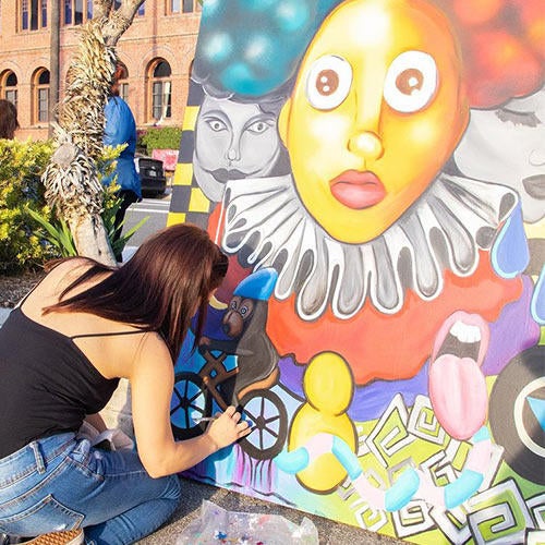 An artist adds final touches to her painting at Riverside's Art Walk.