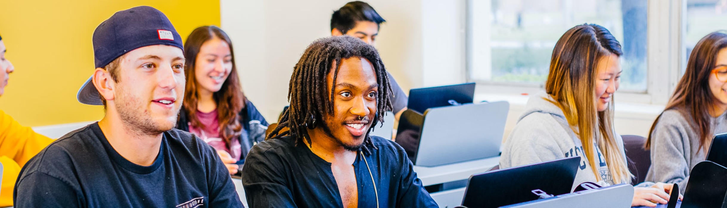 A group of UC Riverside students work on laptops in a classroom