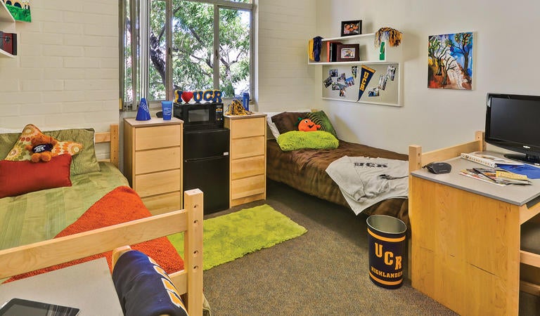 Two beds on either side of a decorated dorm room 