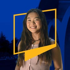 Student Vanessa Wu smiles while wearing wavy dark hair, and a sleeveless top. Her upper body is framed by a UCR icon border. The blue-tinted background features the iconic Tomás Rivera Library arches on campus.