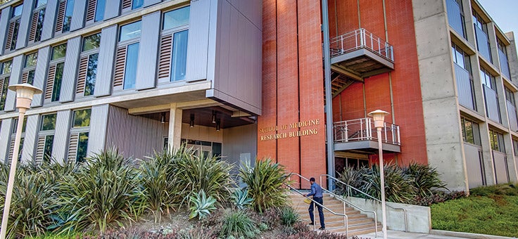 A person walks up the steps of the School of Medicine Research Building