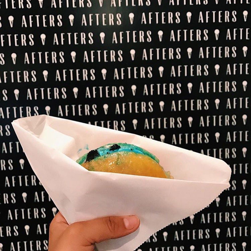 Someone holding a blue ice cream donut sandwich at Afters Ice Cream.