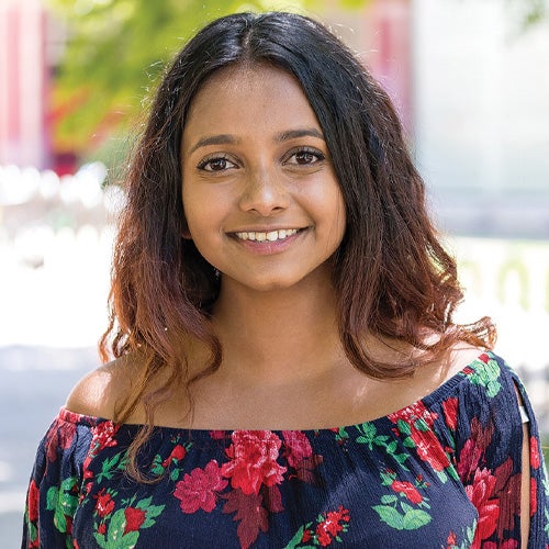 UCR international grad student, Viresha Perera, smiles outside on campus.